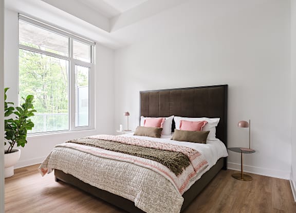 A bedroom with a large bed and a potted plant at Petries Landing I Apartments , Ontario, K4A 1K4