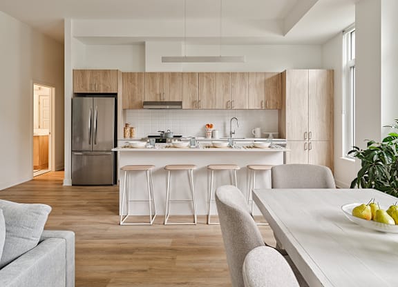 A modern kitchen with a dining table and chairs at Petries Landing I Apartments , Ottawa, ON, K4A 1K4