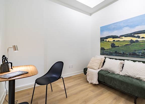 Modern living room with green sofa and artwork at Petries Landing II Apartments, Ottawa, ON