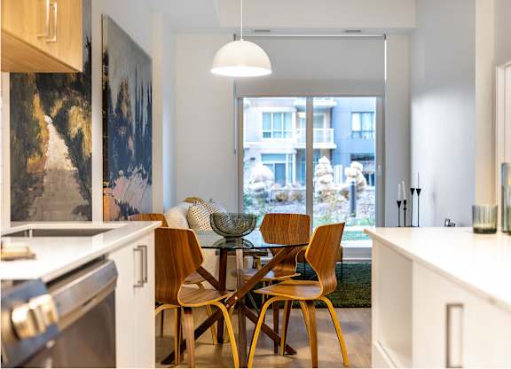 Modern dining area with glass table and wood chairs at Petries Landing II Apartments, Ottawa, K4A 0S8