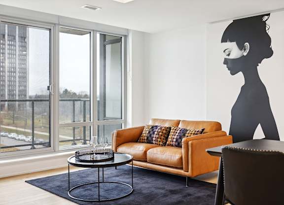 Modern living room with orange leather sofa at Petries Landing II Apartments, Ottawa, Ontario