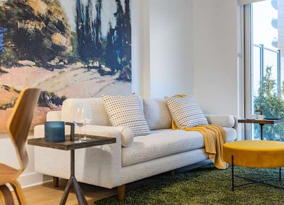 Bright living room with colorful artwork and seating at Petries Landing II Apartments, Ottawa, ON