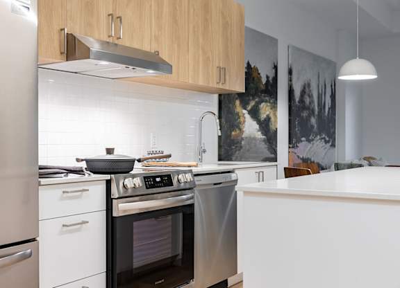 Contemporary kitchen with stainless steel appliances and white countertops at Petries Landing II Apartments, Ottawa, K4A 0S8