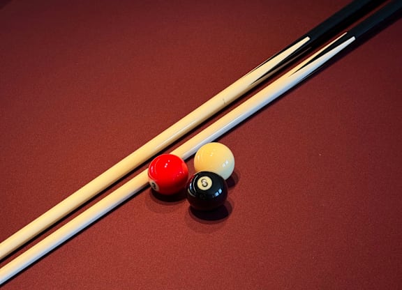 Three pool balls are lined up on a pool table.
