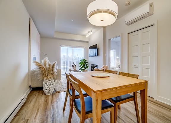 A dining room with a wooden table and chairs at Champlain Village Urbain Apartments , Gatineau, QC