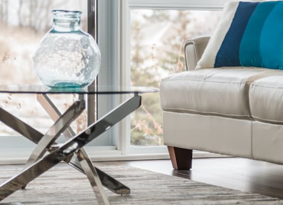 Living room with glass coffee table at Kanata Lakes Apartments, Ottawa, Ontario