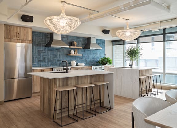 A modern kitchen with a large island and bar stools at The Dale Apartments , Ottawa, K1Y 4Y5