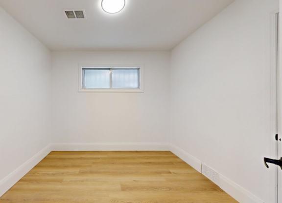 A room with a wooden floor and a small window.