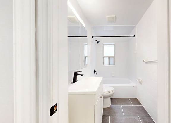 A white bathroom with a toilet, sink, and bathtub.