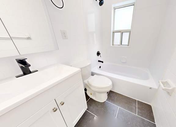 A white bathroom with a toilet, sink, and tub.