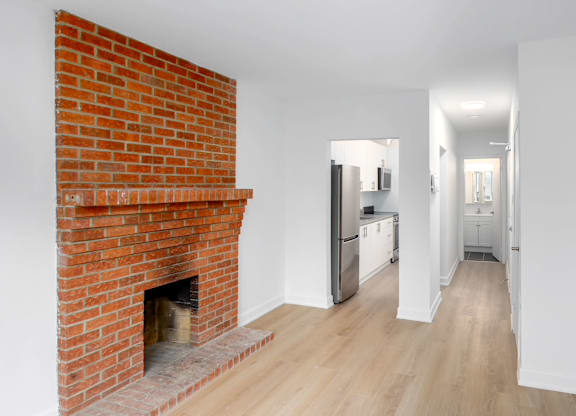 A red brick fireplace in a white room.