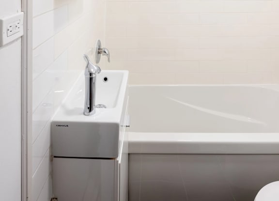 A white bathroom with a sink, toilet, and bathtub.