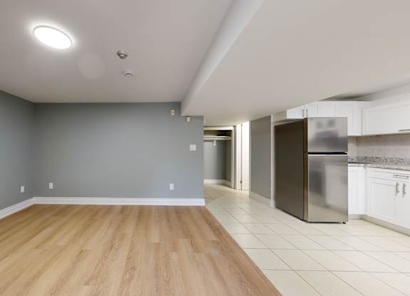 A kitchen with a refrigerator, stove, and oven is visible from the living room.