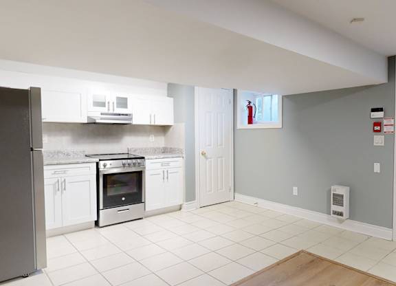 A kitchen with a refrigerator, oven, and microwave.