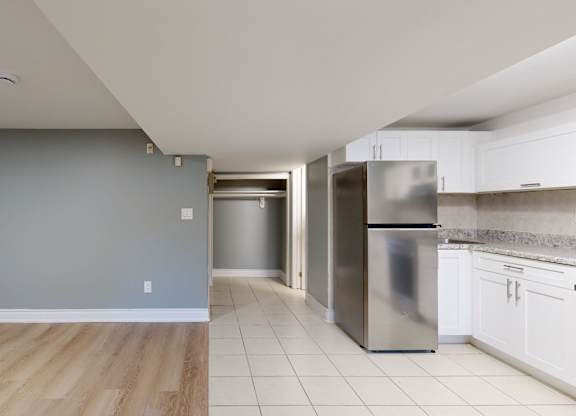 A kitchen with a refrigerator, oven, and cabinets.