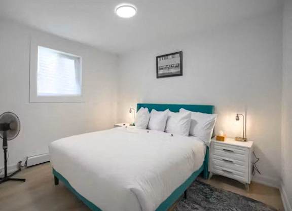 A bedroom with a white bed and a blue headboard.