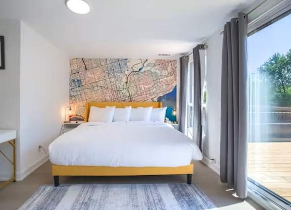 A bedroom with a large bed and a map on the wall.