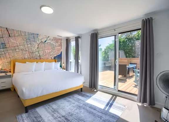 A bedroom with a large bed and a map on the wall.
