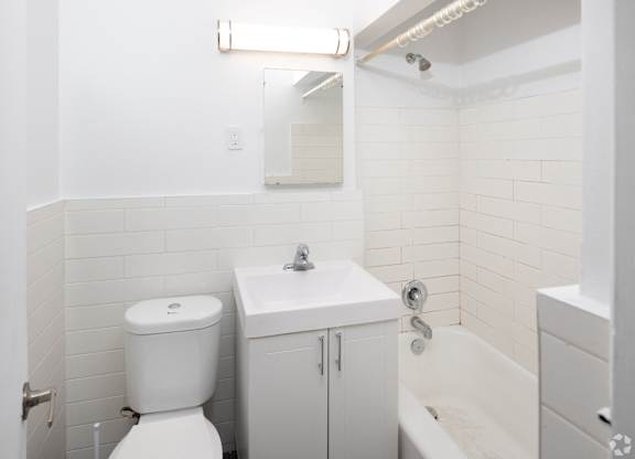 A white toilet sits next to a sink in a small bathroom.