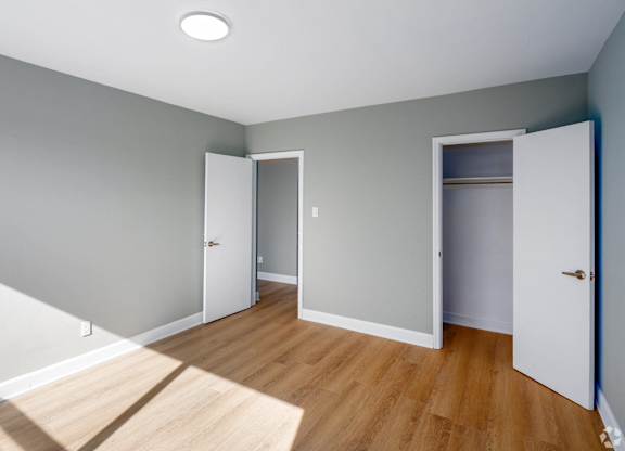 A room with a white door and a white cabinet with a light on the ceiling.