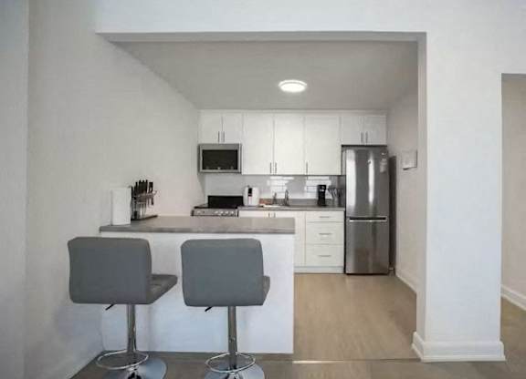A kitchen with two grey bar stools.