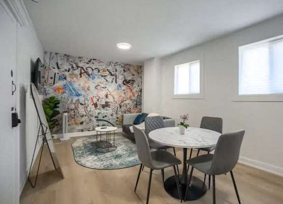 A dining room with a white table and chairs.