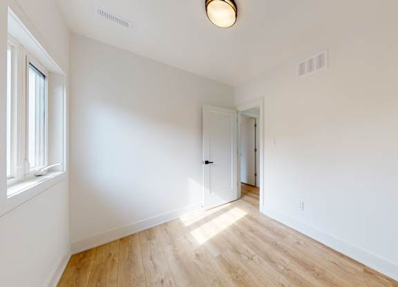 A room with a wooden floor and white walls.