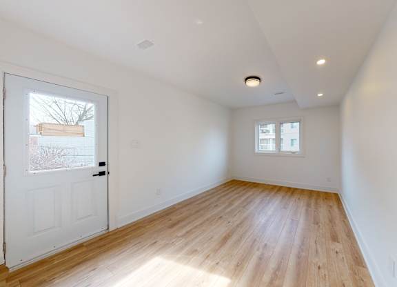 A room with wooden flooring and white walls.