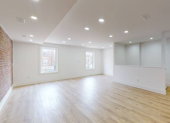A large empty room with wooden floors and white walls.