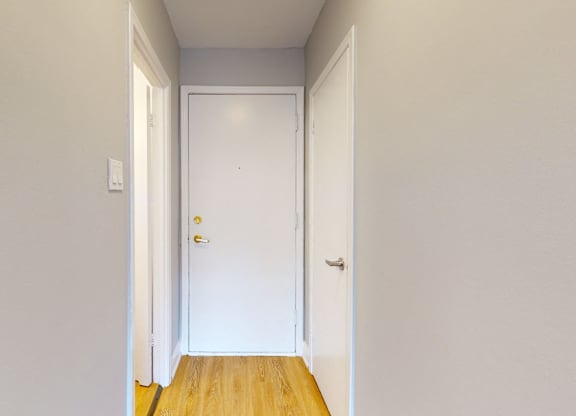 A white door is in the middle of a hallway.