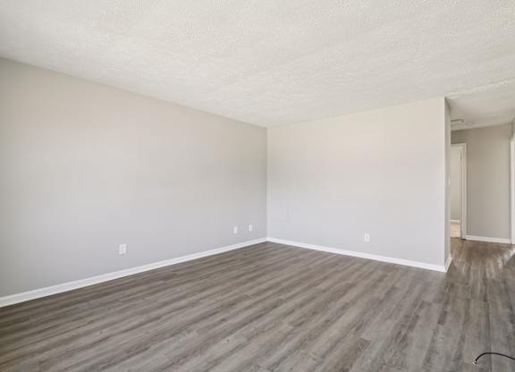 A room with wooden flooring and white walls.
