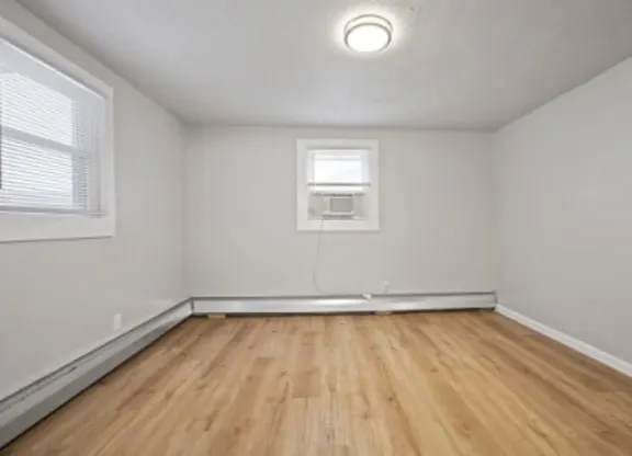 A room with wooden flooring and a window.