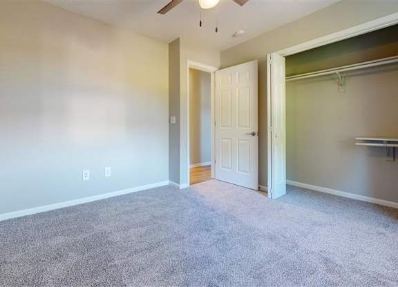 A room with a carpeted floor and a white door at Ridgeview Apartments, Indiana