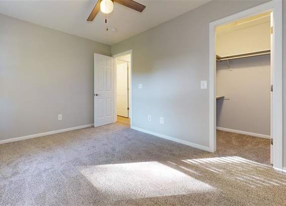 A room with a carpeted floor and a ceiling fan at Ridgeview Apartments, Fortville, IN, 46060