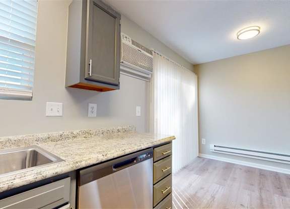 A kitchen with a sink, stove, and a white door at Ridgeview Apartments, Fortville