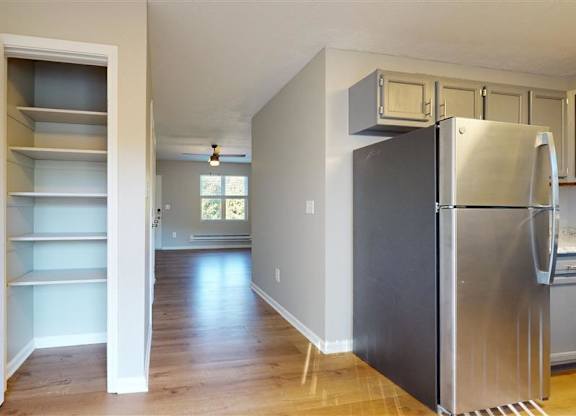 A kitchen with a refrigerator, cabinets, and a doorway leading to another room at Ridgeview Apartments, Indiana