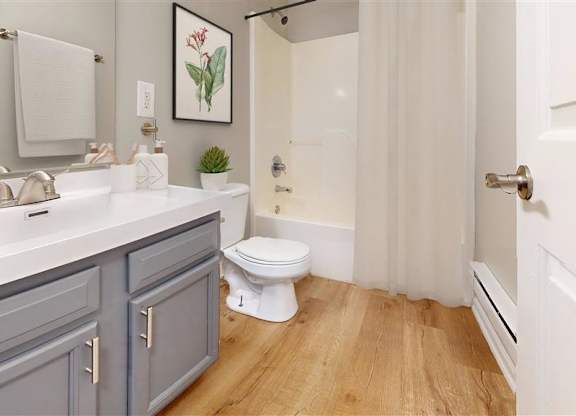 A bathroom with a toilet, sink, and a plant at Ridgeview Apartments, Fortville, IN, 46060