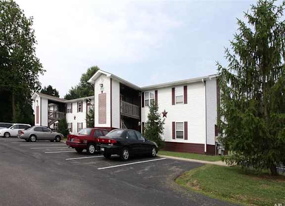 A parking lot with cars and a building with a star on the front at Ridgeview Apartments, Fortville, IN, 46060