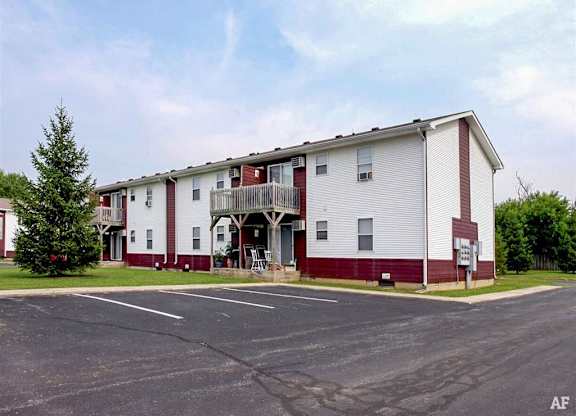 A white and red building with a parking lot in front at Ridgeview Apartments, Fortville, IN