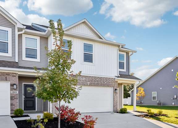 A modern two-story house with a garage and a driveway.