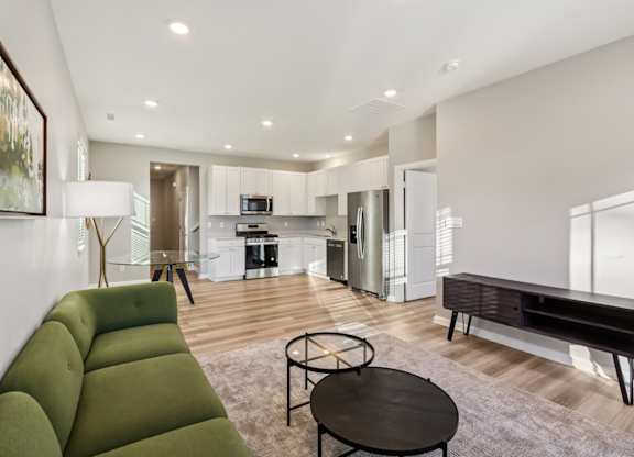 A modern living room with a green sofa and a black coffee table.