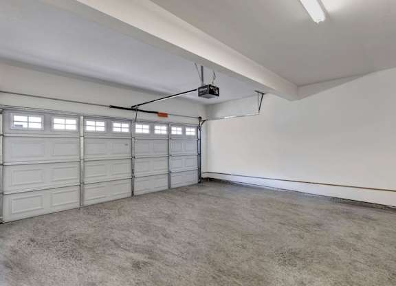 A spacious garage with a white ceiling and a grey floor.