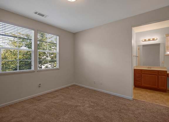 A room with a window and a carpeted floor.