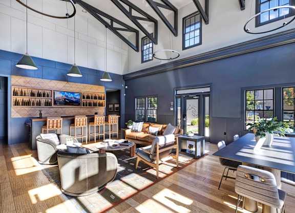 A modern living room with a large couch and a long table.