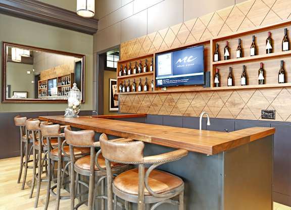 A bar with a wooden counter and stools.