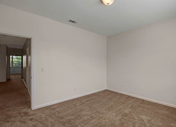 A room with carpeted floor and white walls.