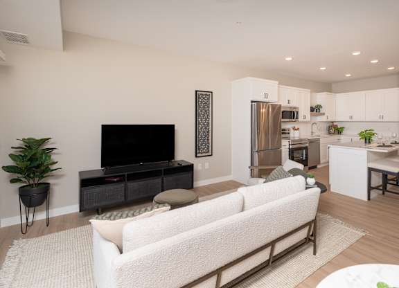 A modern living room with a white couch and a television.
