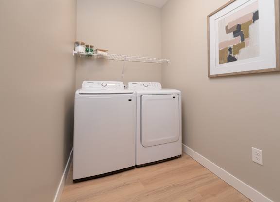 Two white washing machines in a laundry room.