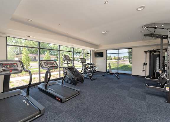A spacious fitness center with treadmills, elliptical machines, and other exercise equipment.