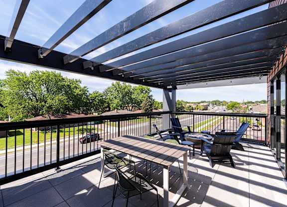 A patio with a table and chairs under a roof.